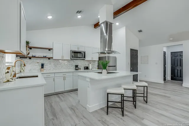 a kitchen with cabinets a sink dishwasher a stove and a refrigerator with wooden floor