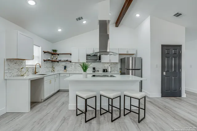 a kitchen with granite countertop a sink stainless steel appliances and cabinets