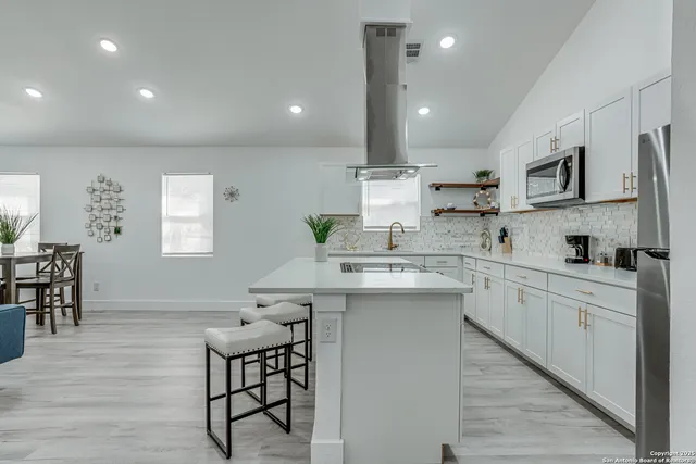 a kitchen with a refrigerator and white cabinets