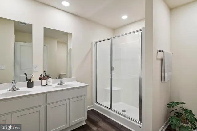 a bathroom with a double vanity sink mirror and shower