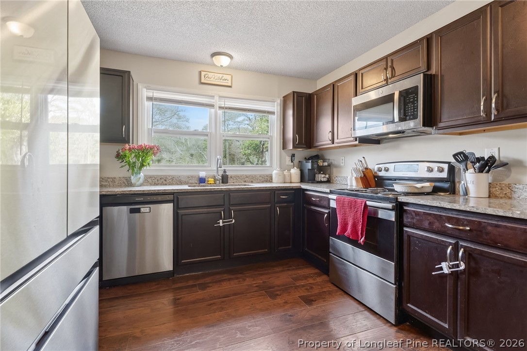 1083 Strickland Bridge Road Fayetteville, NC 28304 - Photo 2 of 25 a kitchen with a sink stove and microwave