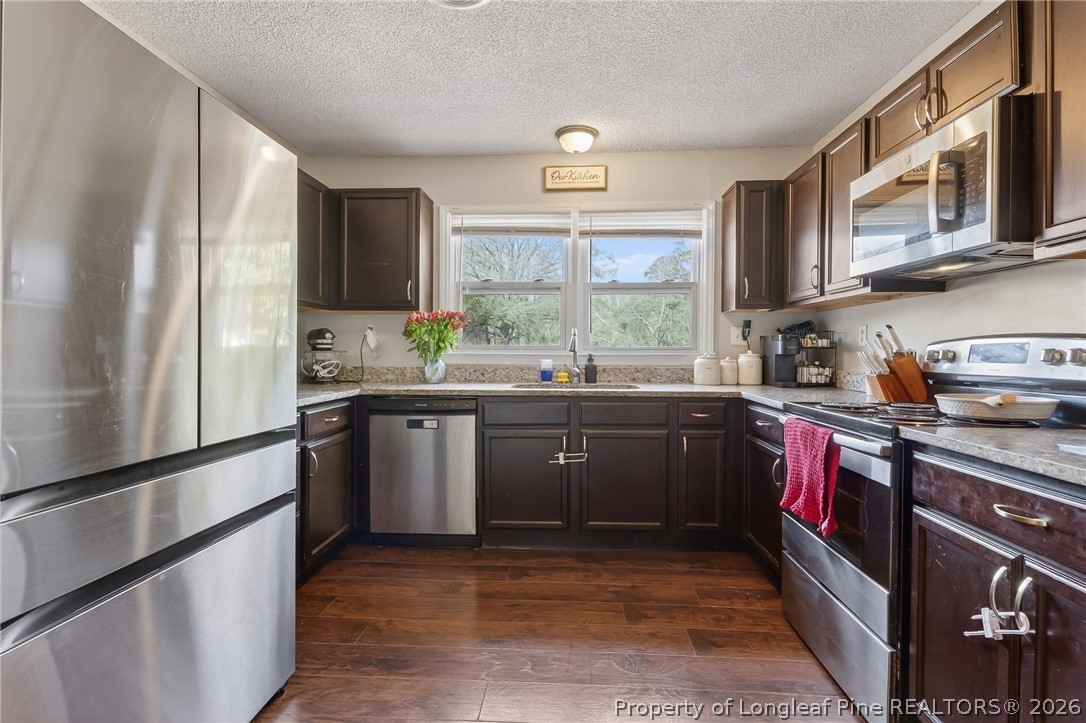 1083 Strickland Bridge Road Fayetteville, NC 28304 - Photo 3 of 25 a kitchen with stainless steel appliances granite countertop a sink a stove a refrigerator cabinets and a window