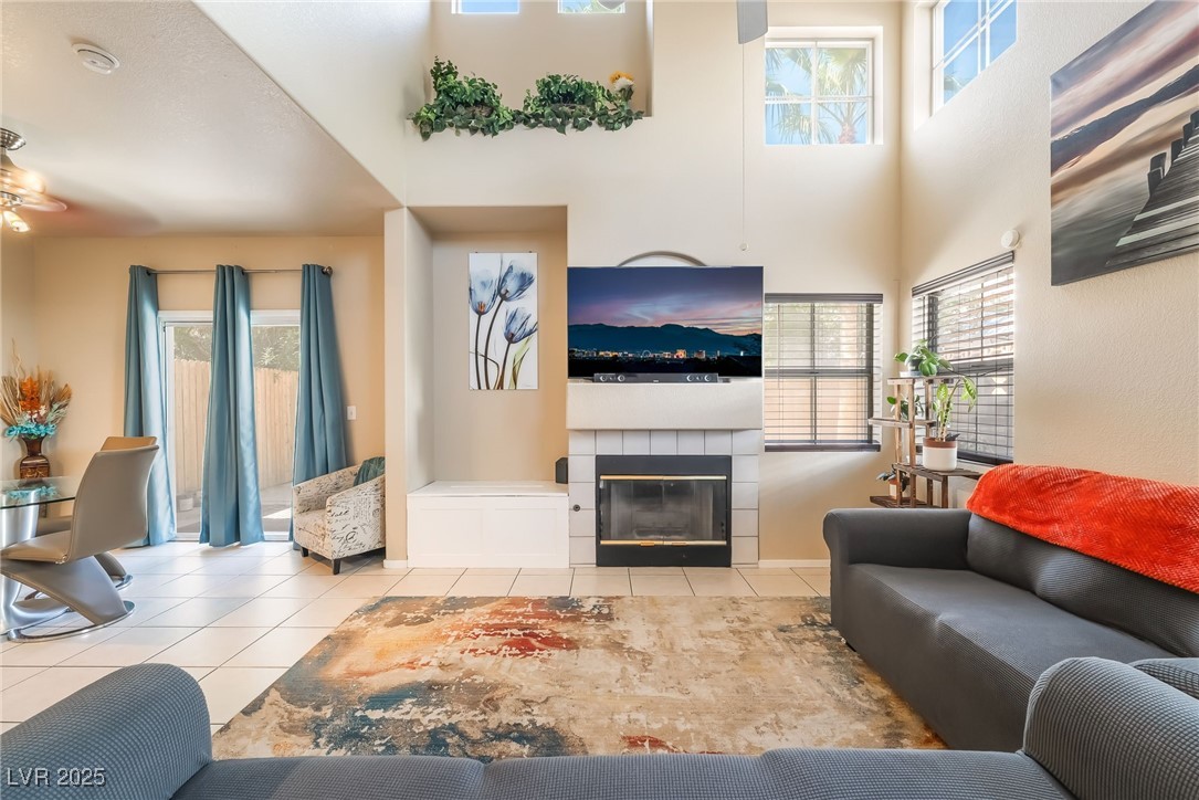 5322 Runningbrook Road Las Vegas, NV 89120 - Photo 2 of 25 Tiled living room with a tile fireplace, a high ceiling, and ceiling fan