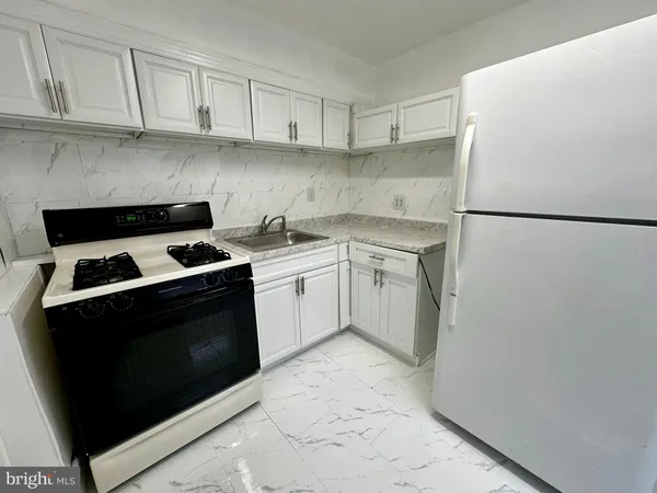 a kitchen with a stove sink and refrigerator