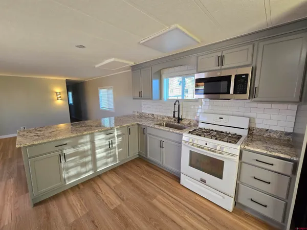 a kitchen with stainless steel appliances white cabinets a sink and a stove