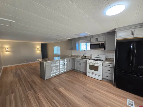 a kitchen with stainless steel appliances a stove top oven and refrigerator
