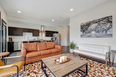 a living room with furniture and a dining table with kitchen view