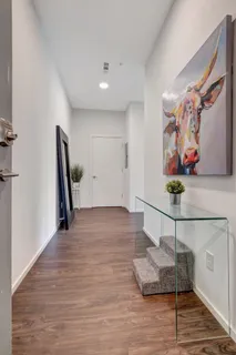 a view of a hallway with wooden floor and furniture