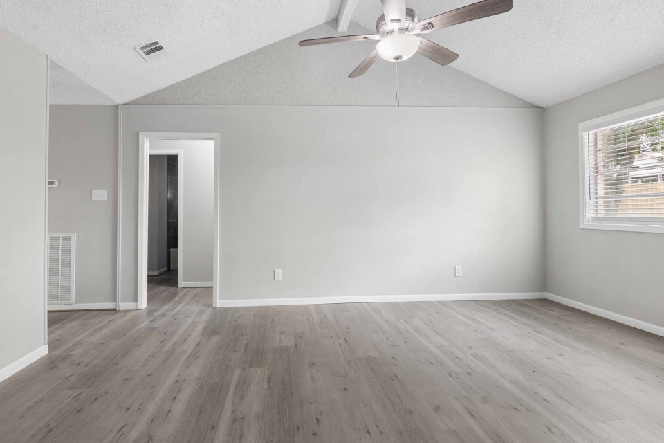7403 Strawbridge Lane Houston, TX 77040 - Photo 6 of 22 an empty room with wooden floor fan and windows