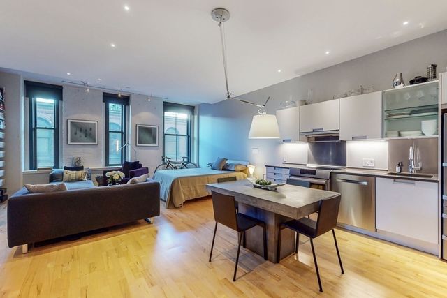 a kitchen with stainless steel appliances granite countertop a stove a sink dishwasher a dining table and chairs with wooden floor