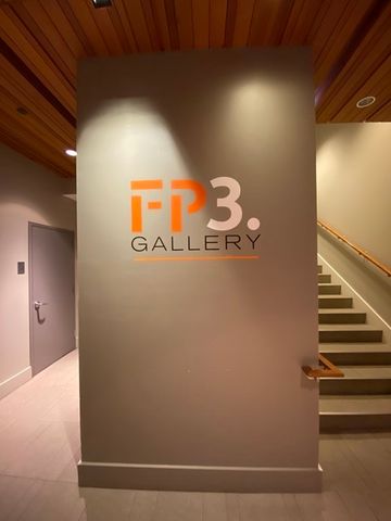 a view of a hall with wooden floor and a potted plant