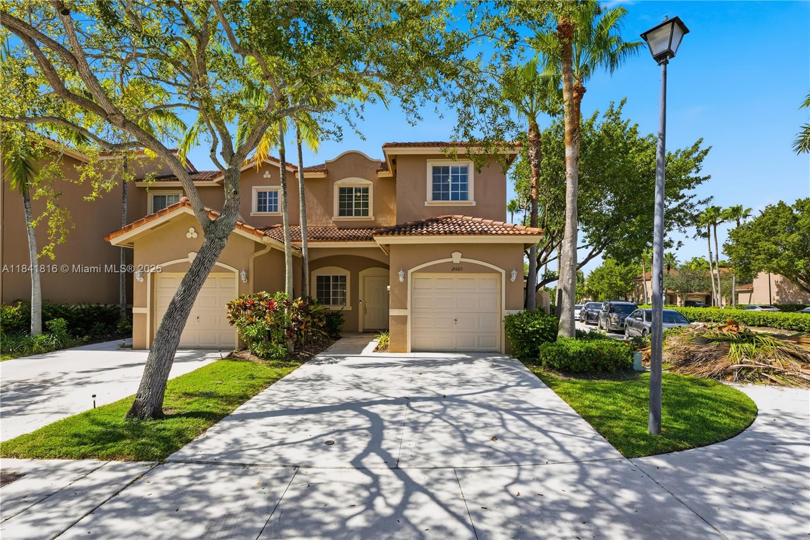 a front view of a house with a yard and trees