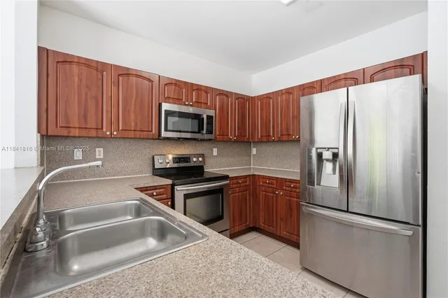 a kitchen with stainless steel appliances granite countertop a refrigerator sink and microwave