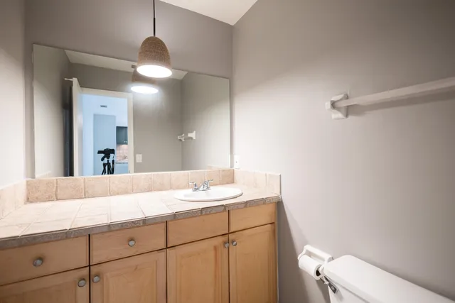 a bathroom with a sink a toilet and a mirror