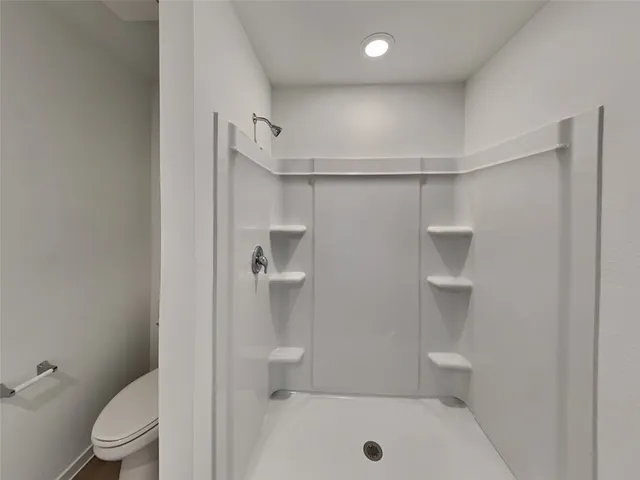 a bathroom with a toilet and a shower