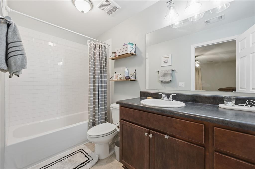 1007 Olde Mill Lane Norcross, GA 30093 - Photo 21 of 32 a bathroom with a granite countertop sink toilet a mirror and shower