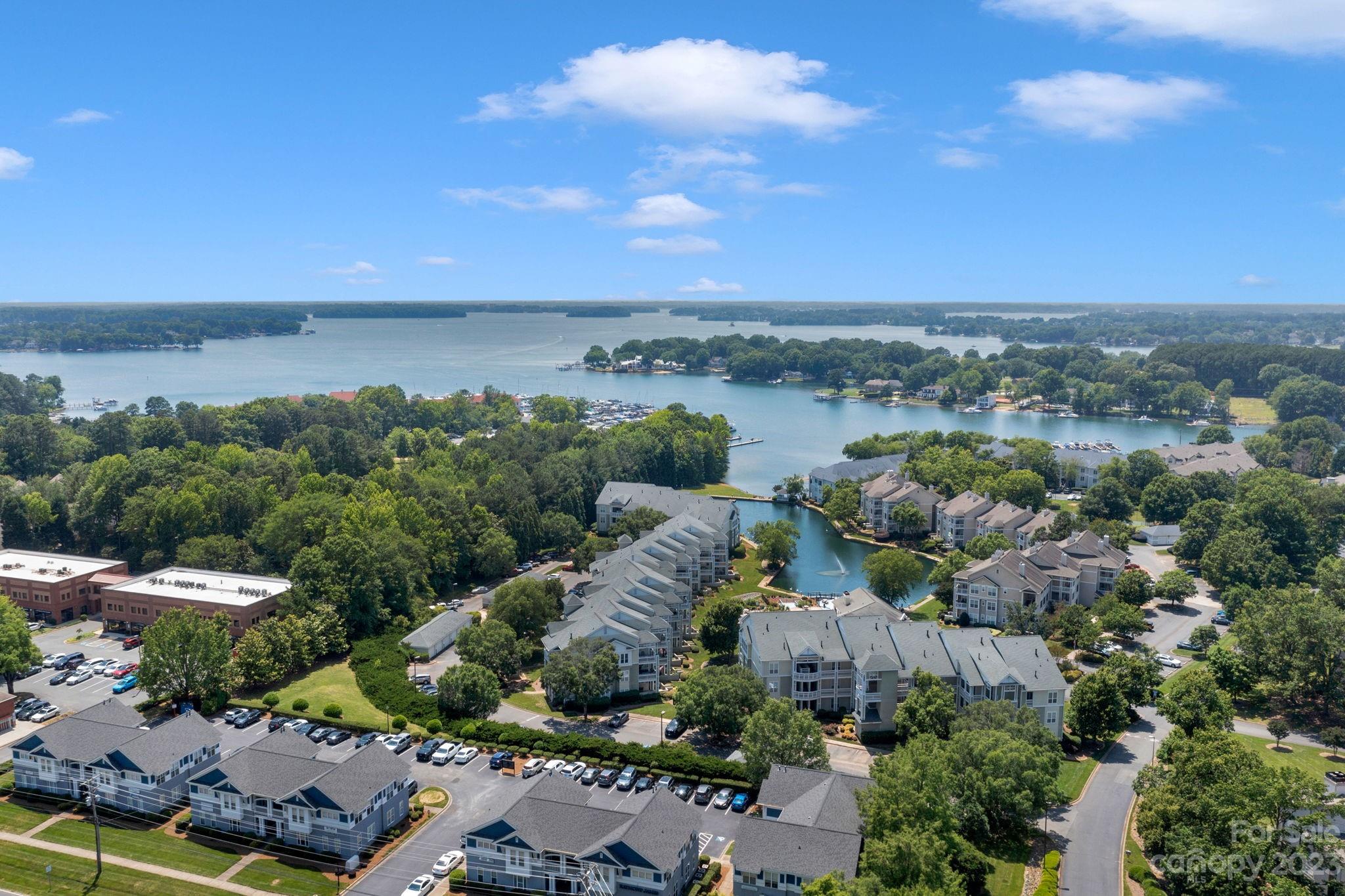 an aerial view of a city with lots of residential buildings ocean and mountain view in back