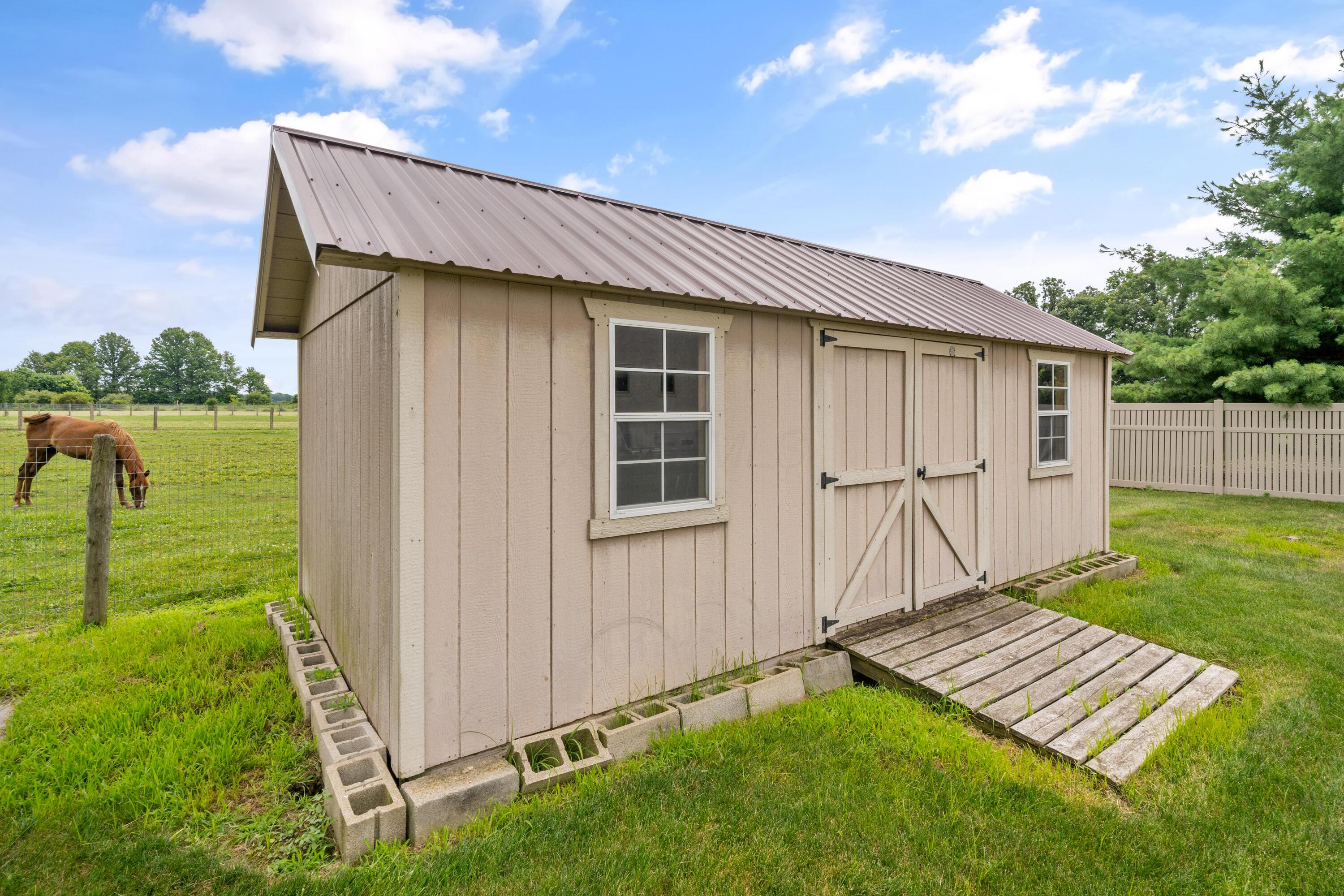 4640 Maynard Road Delaware, OH 43015 - Photo 60 of 91 Detached, oversized shed featuring a metal roof, two windows, and a double-door entry with a wood ramp