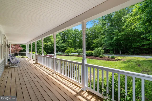 a kitchen with stainless steel appliances granite countertop a sink dishwasher a dining table and chairs with wooden floor