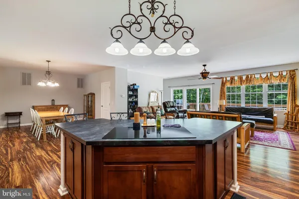 a dining room with wooden floor a chandelier a wooden table and chairs