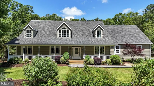 a front view of a house with a yard and potted plants