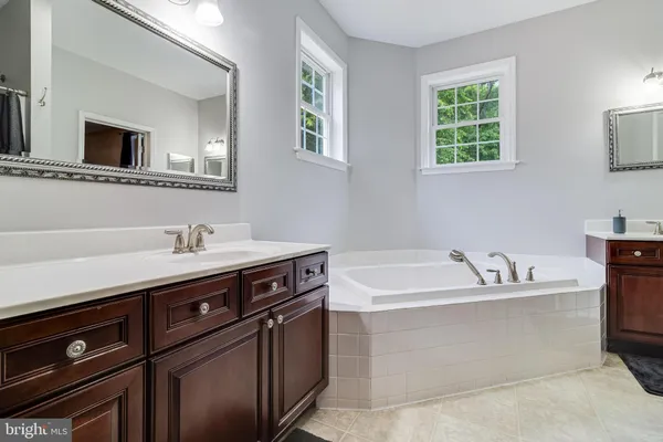 an empty room with chandelier fan and windows