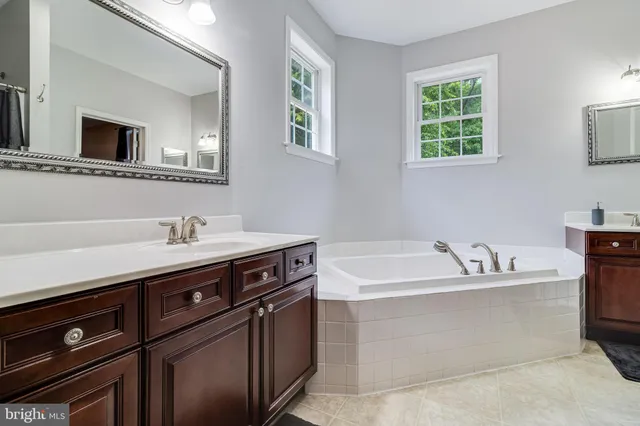 an empty room with chandelier fan and windows