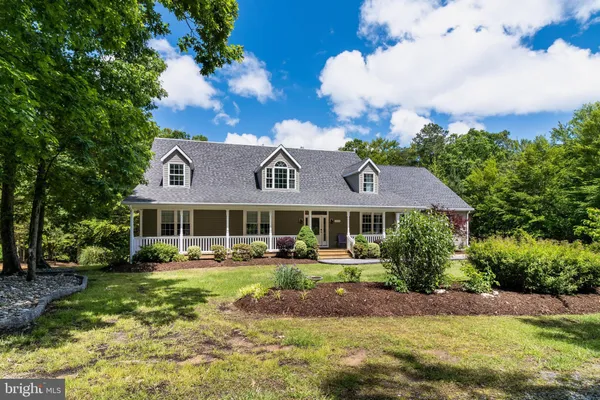 a view of a house with a big yard and large trees