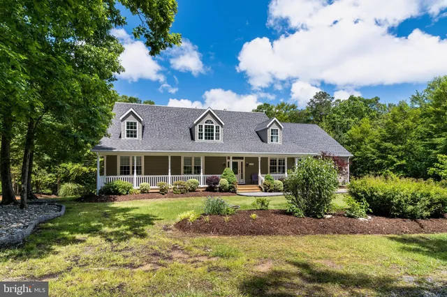 a view of a house with a big yard and large trees