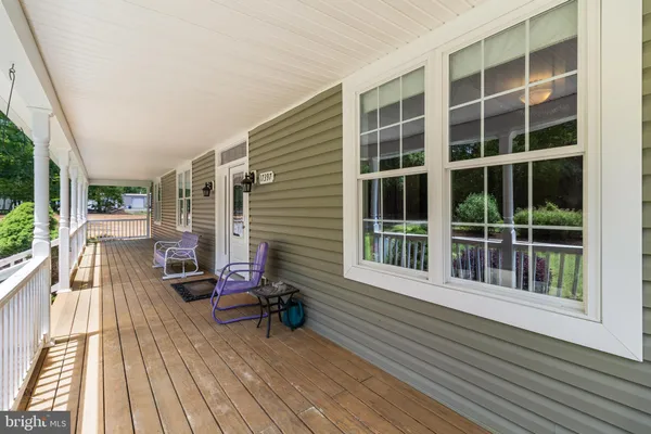 a living room with furniture and a dining table with wooden floor