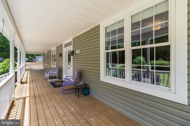 a living room with furniture and a dining table with wooden floor