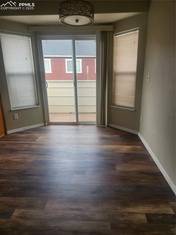 4806 Rusty Nail Point, Unit 202 Colorado Springs, CO 80916 - Photo 14 of 24 Empty room featuring a textured wall and dark wood-type flooring