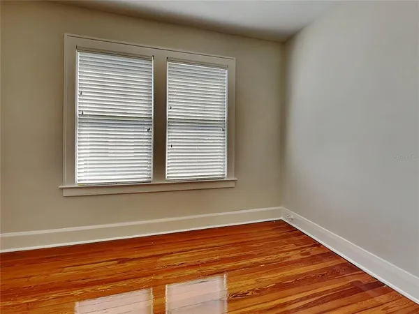 a view of a room with wooden floor and a window