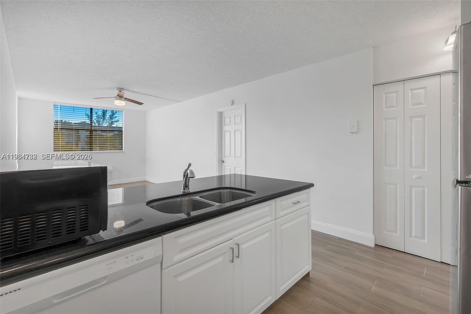 2501 Riverside Drive, Unit 307A Coral Springs, FL 33065 - Photo 11 of 29 a kitchen with granite countertop white cabinets and a sink