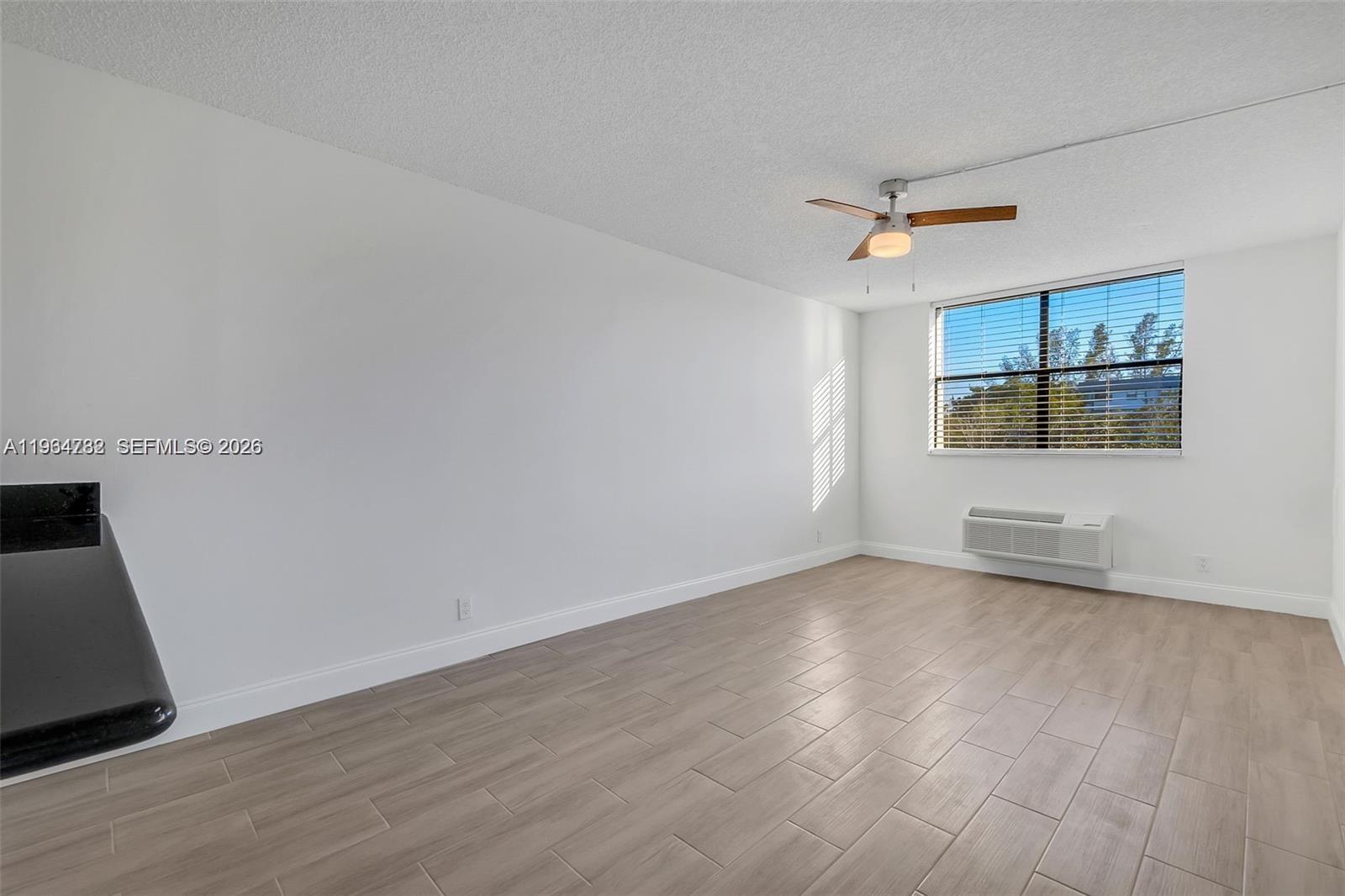 2501 Riverside Drive, Unit 307A Coral Springs, FL 33065 - Photo 5 of 29 an empty room with wooden floor and ceiling fan