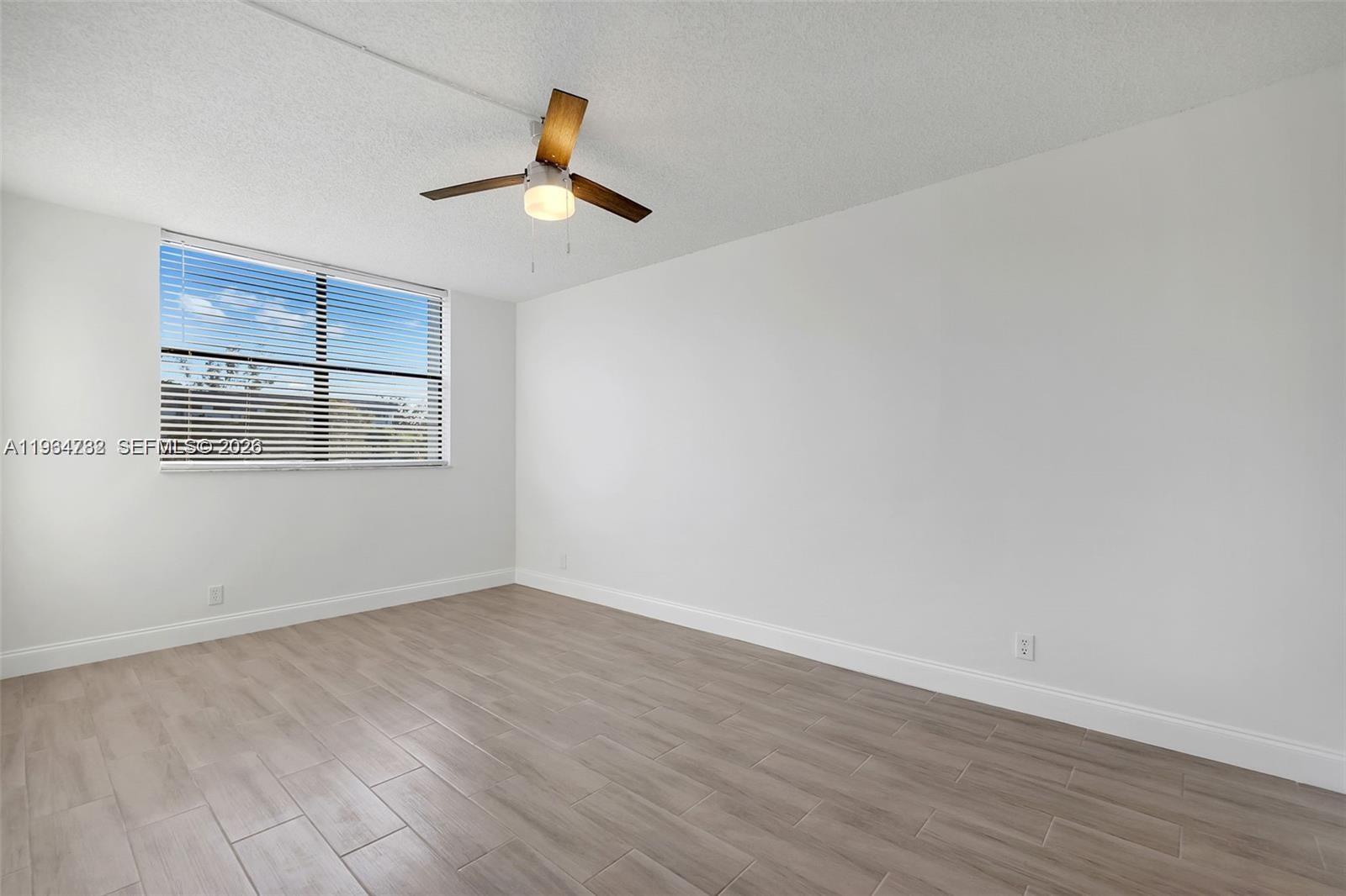 2501 Riverside Drive, Unit 307A Coral Springs, FL 33065 - Photo 6 of 29 a view of empty room with wooden floor and fan