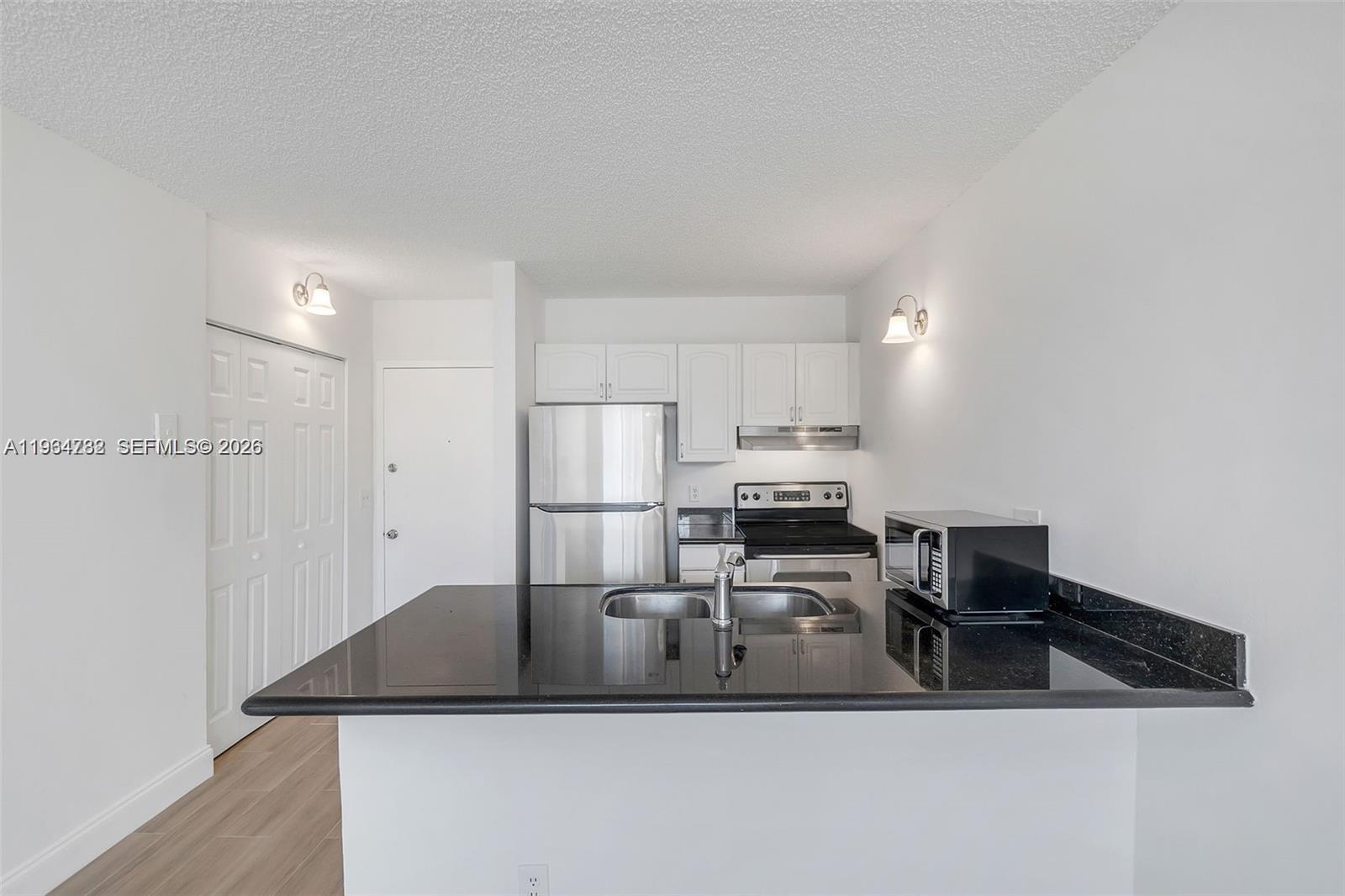 2501 Riverside Drive, Unit 307A Coral Springs, FL 33065 - Photo 7 of 29 a kitchen with kitchen island a stove a refrigerator and a sink