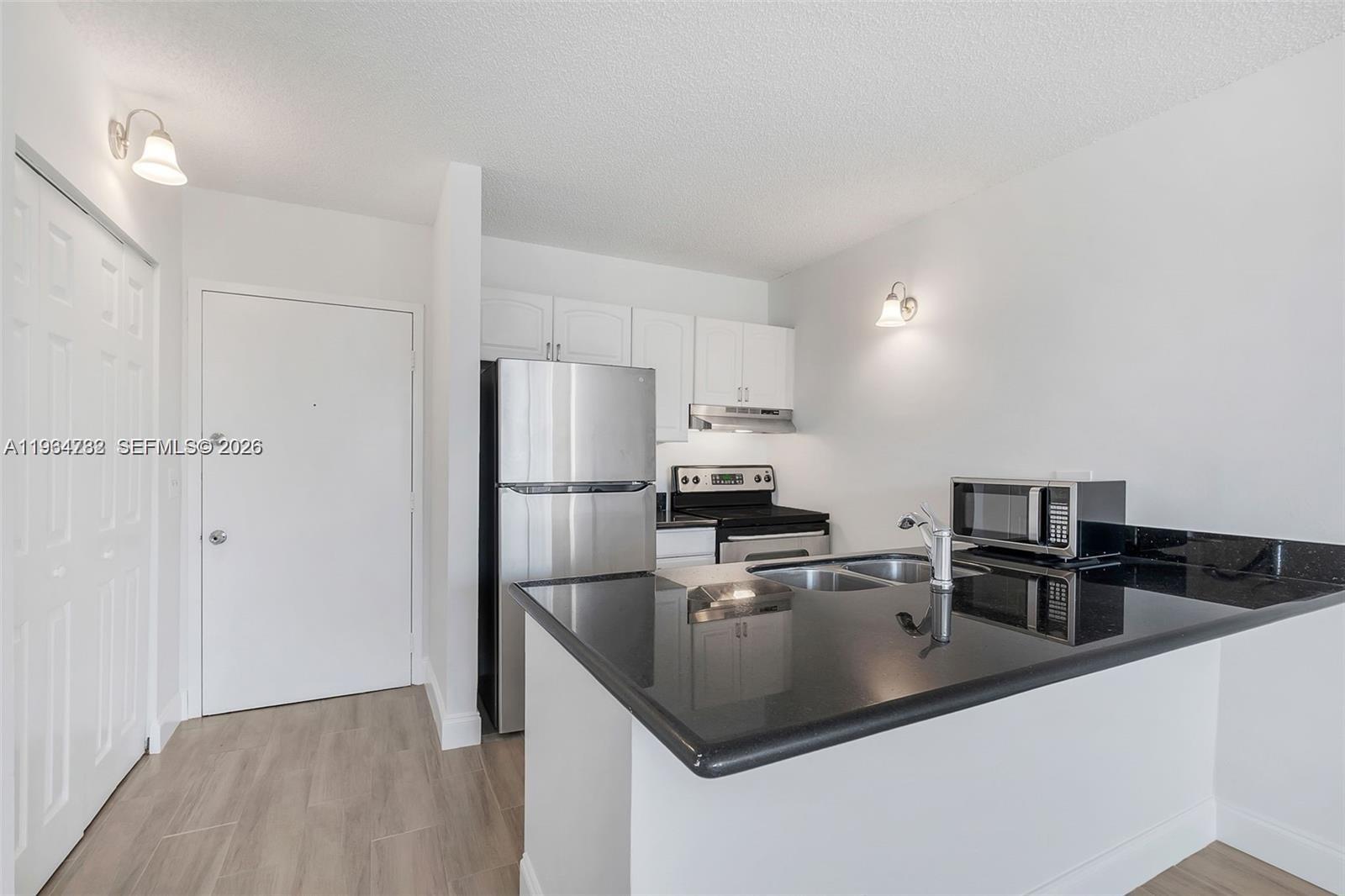 2501 Riverside Drive, Unit 307A Coral Springs, FL 33065 - Photo 8 of 29 a kitchen with stainless steel appliances granite countertop a sink a stove and a refrigerator
