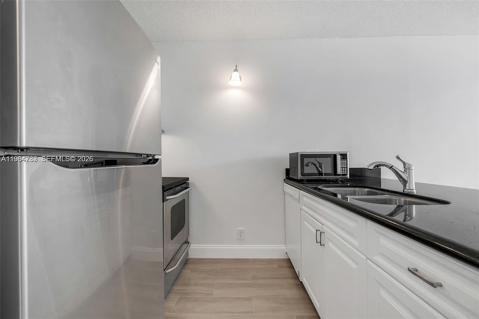 2501 Riverside Drive, Unit 307A Coral Springs, FL 33065 - Photo 9 of 29 a kitchen with a sink and refrigerator