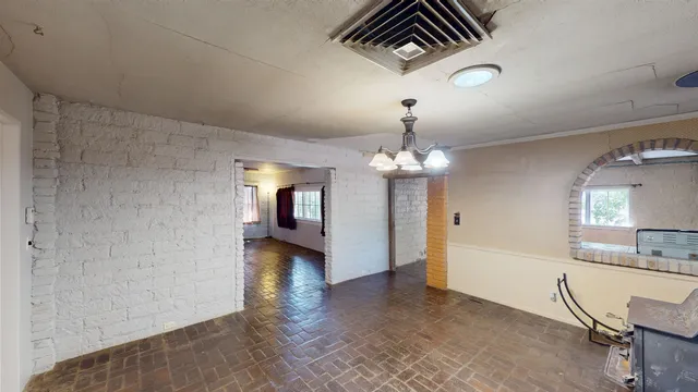 a view of a livingroom with a fireplace a chandelier furniture and windows