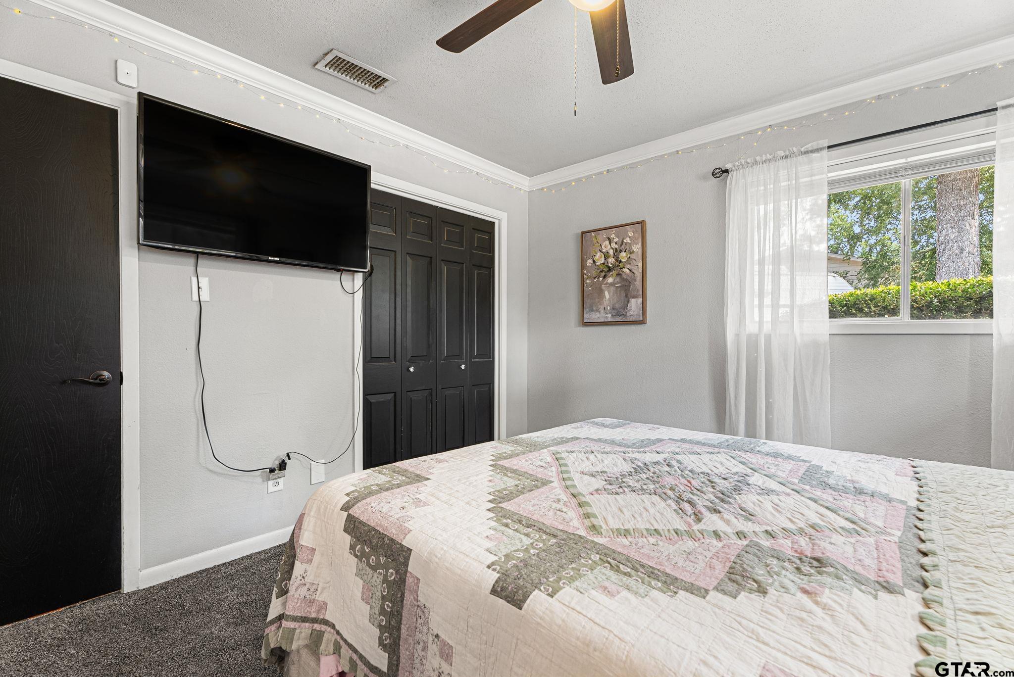 3200 Charron Avenue Longview, TX 75601 - Photo 15 of 34 a bedroom with a bed a flat screen tv and a large window