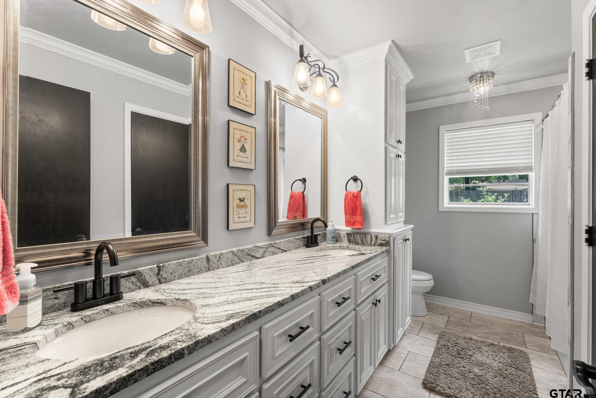 3200 Charron Avenue Longview, TX 75601 - Photo 21 of 34 a bathroom with a granite countertop double vanity sink a shower and a mirror