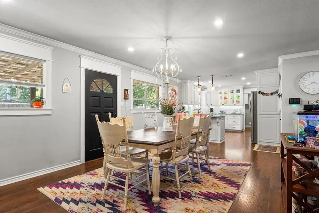 a dining room with furniture a chandelier and wooden floor