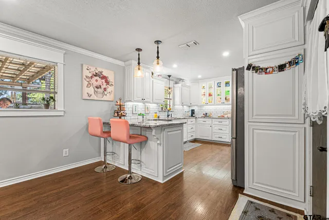a kitchen with kitchen island white cabinets and stainless steel appliances