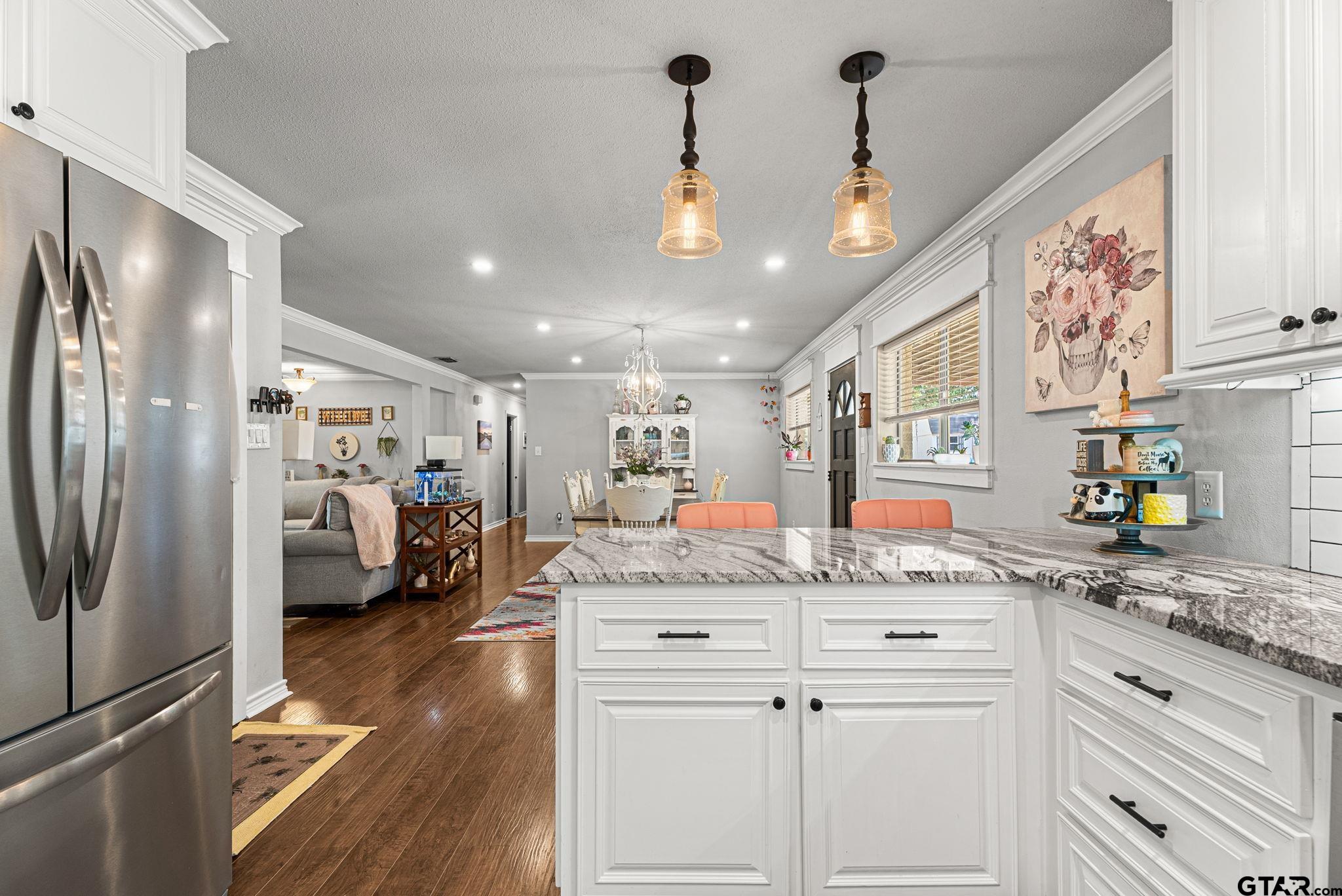 3200 Charron Avenue Longview, TX 75601 - Photo 10 of 34 a kitchen with stainless steel appliances granite countertop a refrigerator a sink dishwasher and white cabinets with wooden floor