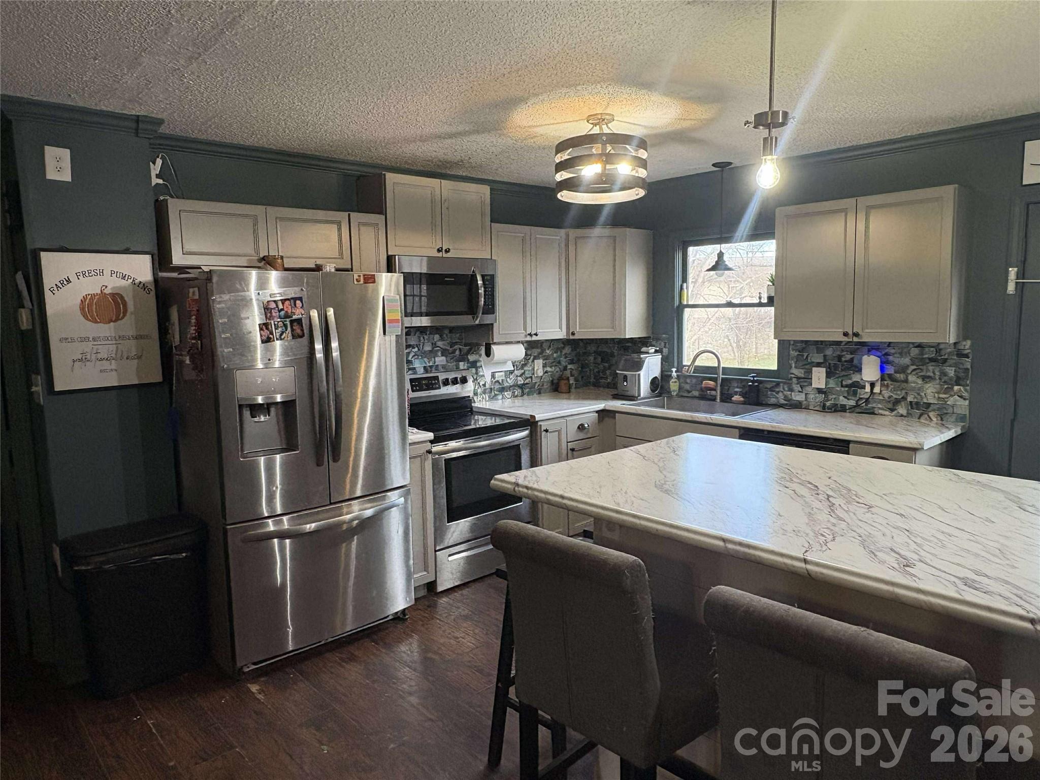 4132 Lower Cedar Valley Road Hudson, NC 28638 - Photo 3 of 5 a kitchen with stainless steel appliances granite countertop a refrigerator a stove a sink dishwasher and a refrigerator with wooden floor
