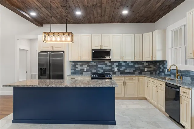 a kitchen with stainless steel appliances granite countertop a sink a stove and a microwave