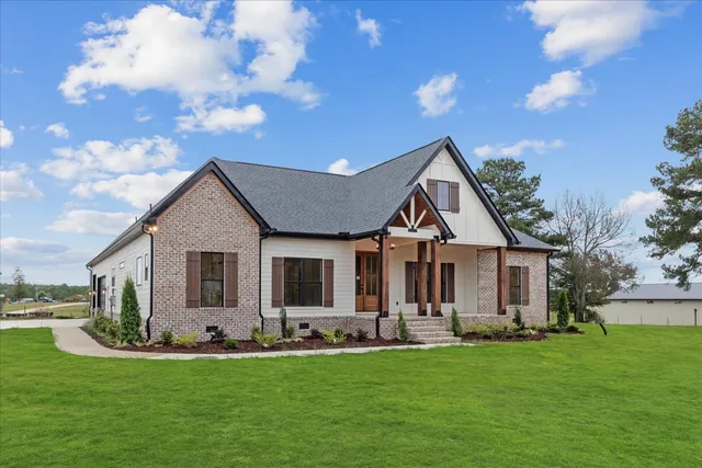 a front view of a house with a garden and yard