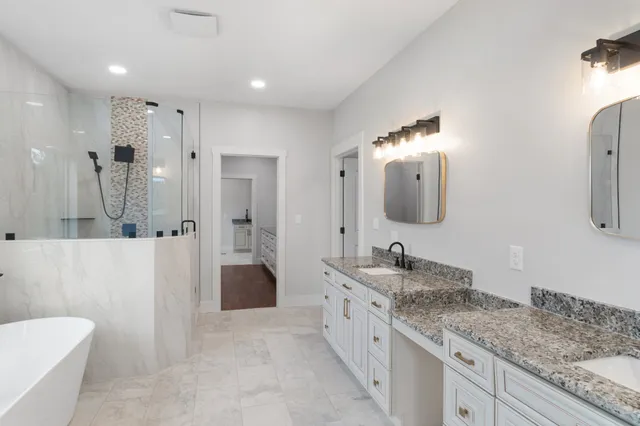 a spacious bathroom with a granite countertop sink mirror and shower