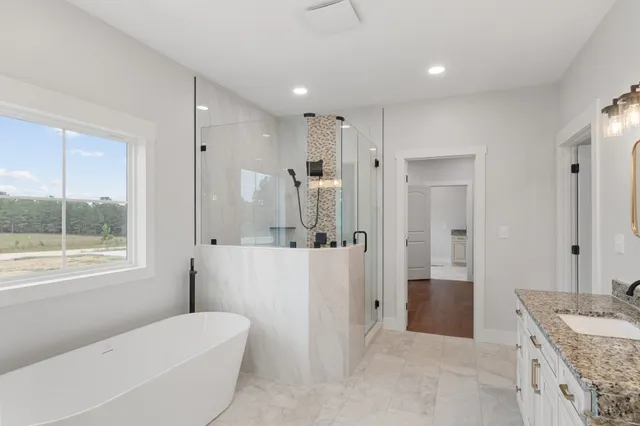 a bathroom with a granite countertop sink a toilet a large mirror a shower and bathtub